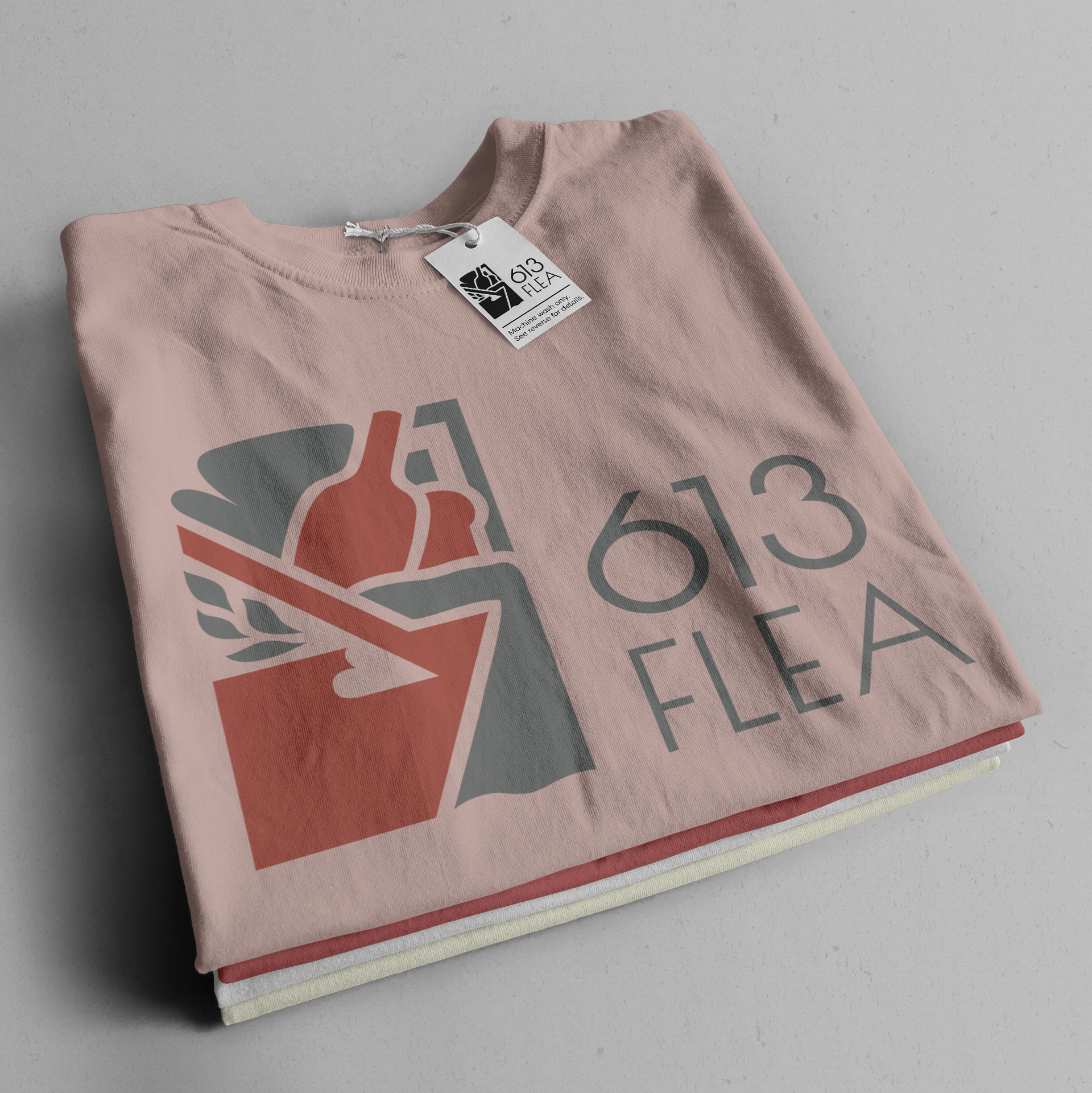 A pile of three folded shirts, which display the 613 flea logo.