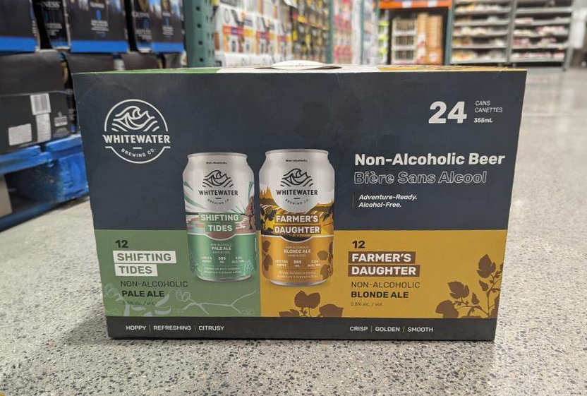 Non-Alcoholic beer case sitting on the floor in front of stocked Costco shelves.